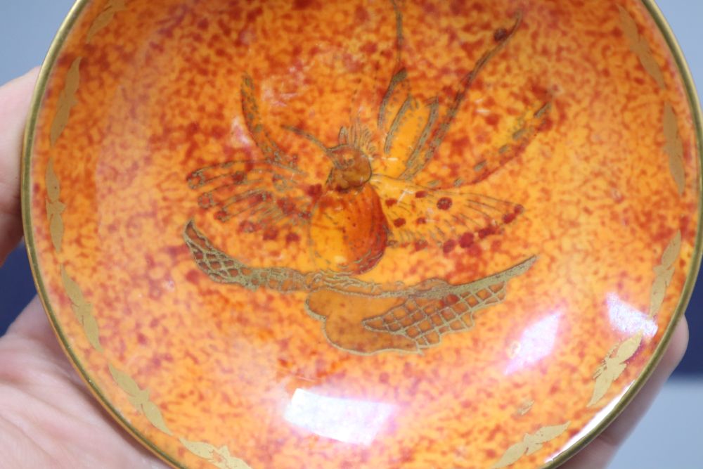 An orange glazed Wedgwood lustre dish, decorated with bird of paradise, diameter 9.5cm